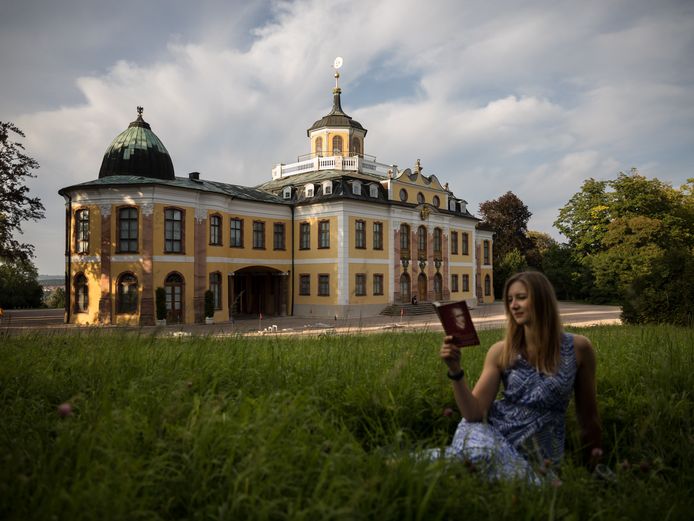 Schloss Belvedere lesende Frau im Gras vor dem Schloss Belvedere