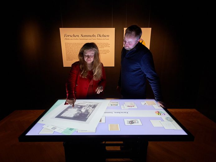 Multi-Touch-Tisch Zwei Menschen stehen vor einem digitalen Tisch und bewegen Objekte