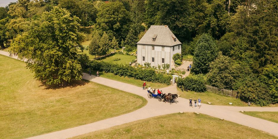 Goethes Gartenhaus Luftaufnahme von Goethes Gartenhaus und Gehweg, auf der eine Kutsche mit Pferden fährt