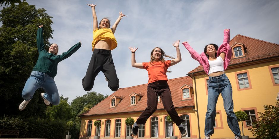 Education and mediation Young people jump into the air in front of Wielandgut Oßmannstedt