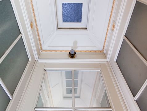 Schlosskissen-Motiv Stadtschloss Blick nach oben zur Decke eines aus um 1900 stammender Fahrstuhl