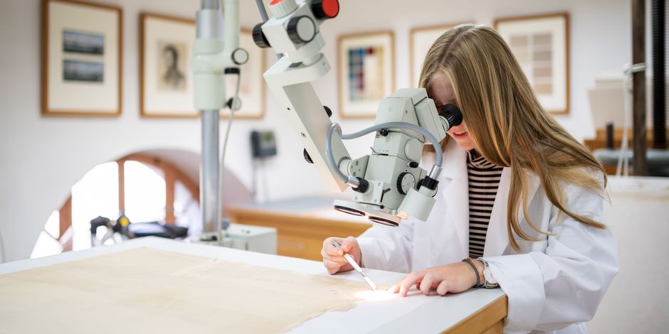 Graphikrestaurierung Eine Restauratorin am Mikroskop