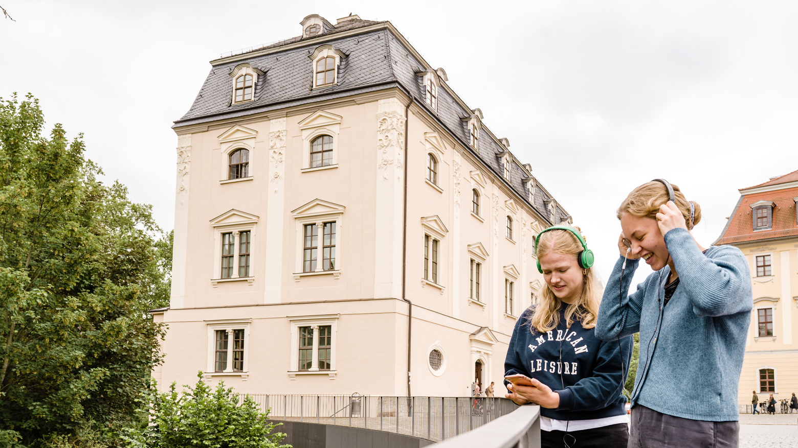 App Weimar+ Zwei Frauen lachen und unterhalten sich gut beim Anhören eines Audiowalks