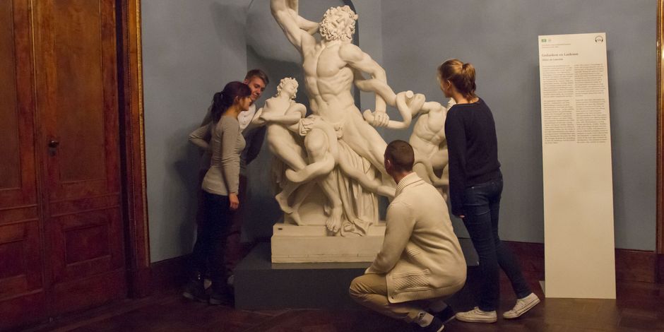 Jugendliche betrachten und untersuchen Marmorskulptur
