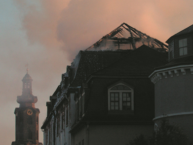 Der verbrannte Dachstuhl der Bibliothek im Morgenlicht, im Hintergrund der Schlossturm