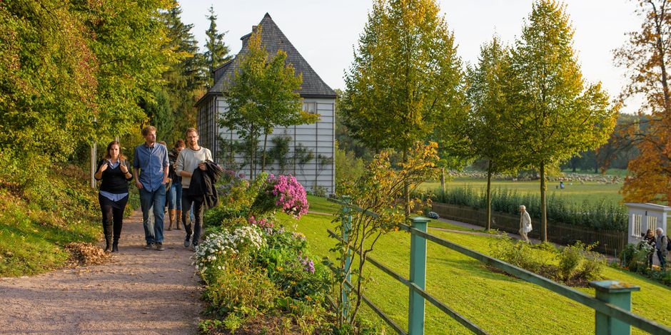Bildung und Vermittlung Erwachsenengruppe läuft durch den blühenden Garten am Goethe Gartenhaus