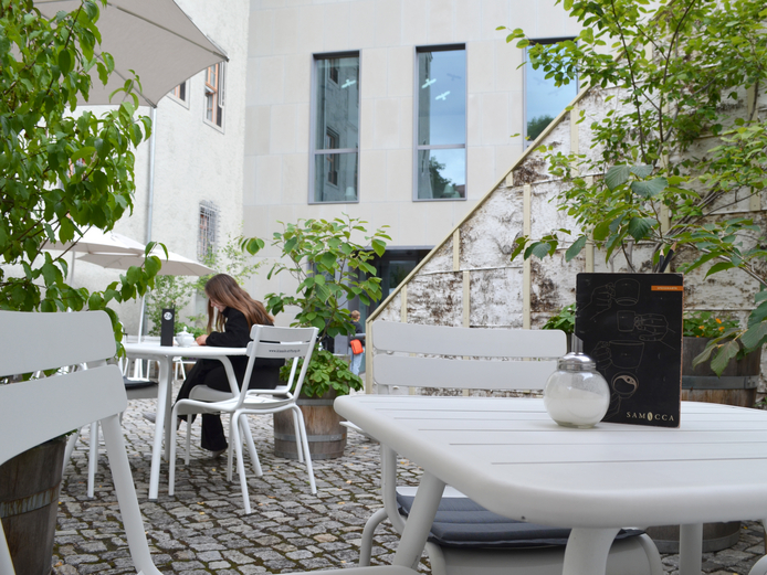 Café Samocca Ein weißer Tisch mit Stühlen
